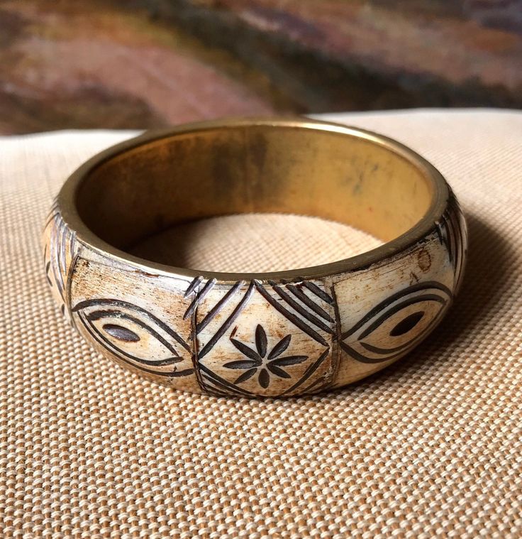 This wonderful tribal bone bangle bracelet is in great vintage condition. It is carved bone with brass spacers. It is 1" wide and 3 1/4: round. The inside measure 2 1/2' round. Most vintage items are old and pre-owned so they may have some degree of wear and imperfections and are sold in as-is condition. Sorry, all sales are final so this item is non-refundable. So please look it over carefully and ask me any questions before making the purchase. Due to the fact that I sell many vintage items of different sizes and weights, if you are purchasing more then one item I will adjust the shipping price. I always do my best to provide accurate shipping quotes. Colors may vary due to individual computer monitor settings. All my items come from a smoke-free environment. I try to recycle packaging m Adjustable Bohemian Carved Bracelets, Bohemian Adjustable Carved Bracelets, Adjustable Bohemian Carved Bracelet, Bohemian Cream Bangle Jewelry, Bohemian Cream Bangle, Bohemian Bone-colored Jewelry For Festival, Bohemian Bone Colored Jewelry For Festivals, White Handmade Bohemian Bangle, Vintage Adjustable Cream Bracelets