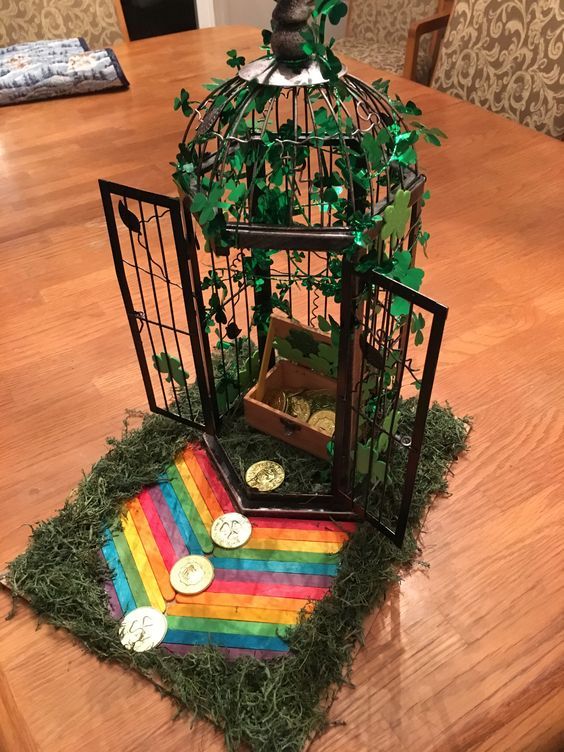 a bird in a cage sitting on top of a wooden table next to a rainbow rug