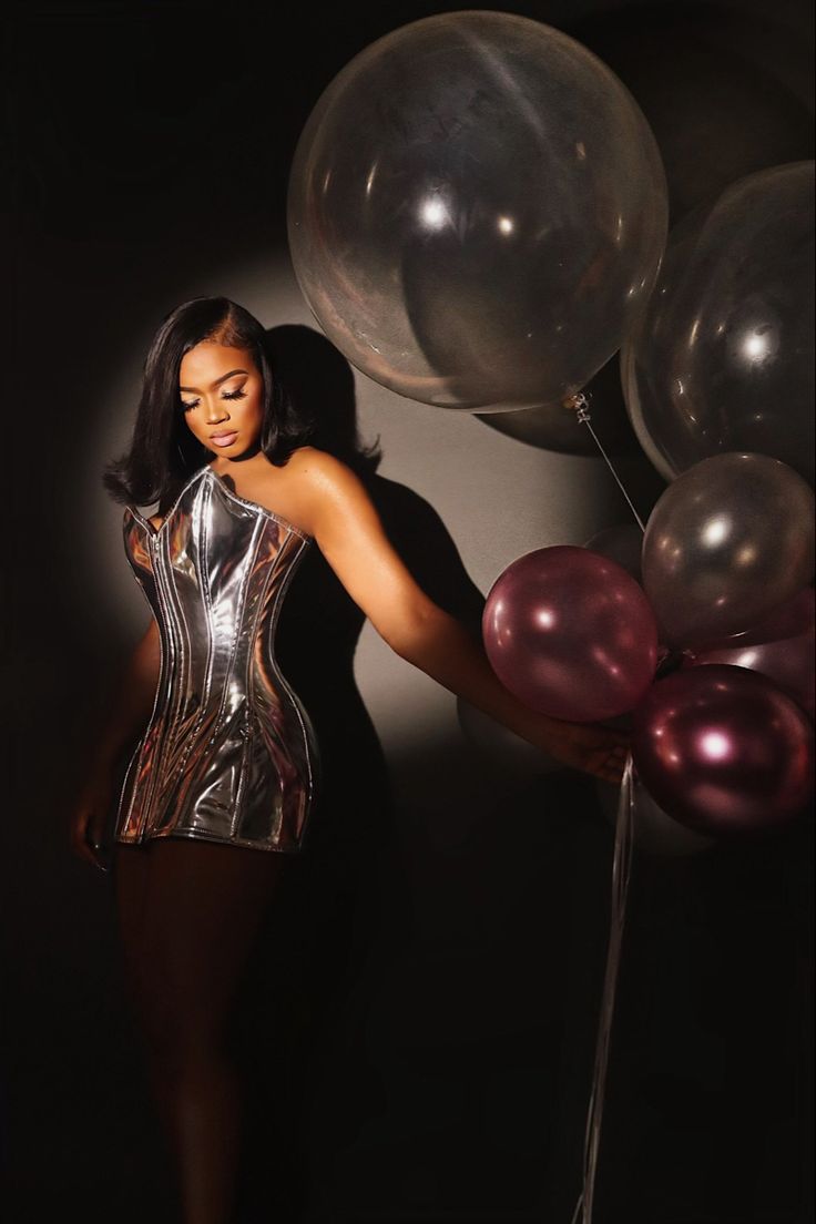 a woman in a silver corset with balloons