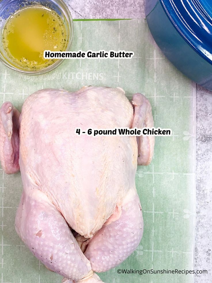 a whole chicken sitting on top of a cutting board next to a bowl of oil