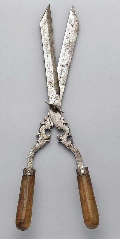 pair of scissors with wooden handles on grey background, possibly from the 19th century or early 20th century