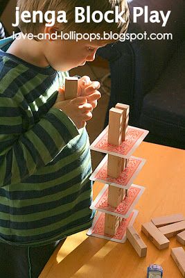 a young boy playing with wooden blocks on a table