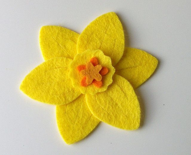 a yellow felt flower with an orange center