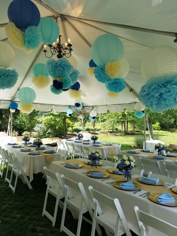 a tent with blue and yellow paper lanterns hanging from the ceiling