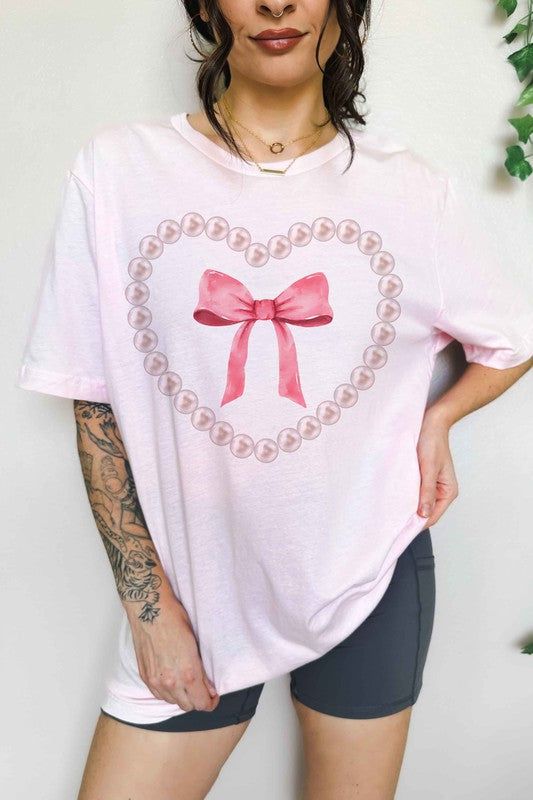 PEARL HEART BOW OVERSIZED GRAPHIC TEEPREMIUM COTTONOVERSIZED FIT Pink Heart Graphic Short Sleeve T-shirt, Pink Heart-shaped Top For Valentine's Day, Pink Heart Shaped T-shirt For Summer, Pink Heart-shaped T-shirt For Summer, Casual Pink T-shirt With Heart Print, Pink Heart Print T-shirt For Summer, Pink Heart Print T-shirt For Spring, Feminine Pink Crew Neck T-shirt, Pink Cotton T-shirt With Heart Graphic