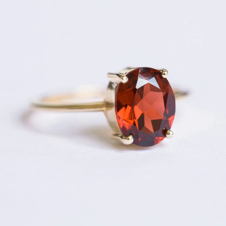 How can something so simple as an oval Garnet solitaire ring, be so beautiful, you ask? The answer is in the gemstone itself. With a gorgeous vivid and deep red color, this ring just pops out on your finger and dazzles everyone. To turn it up a notch, add complimentary stacking rings, to create a one-of-a-kind ring set Red Oval Birthstone Ring With Prong Setting, Oval Ruby Promise Ring, Oval Red Gemstone Birthstone Ring, Oval Red Birthstone Ring In 14k Gold, Oval Solitaire Ruby Ring Gift, Minimalist Oval Ruby Ring For Anniversary, Classic Oval Red Birthstone Ring, Red Oval Birthstone Ring For Proposal, Classic Oval Birthstone Ring With Ethical Gemstones