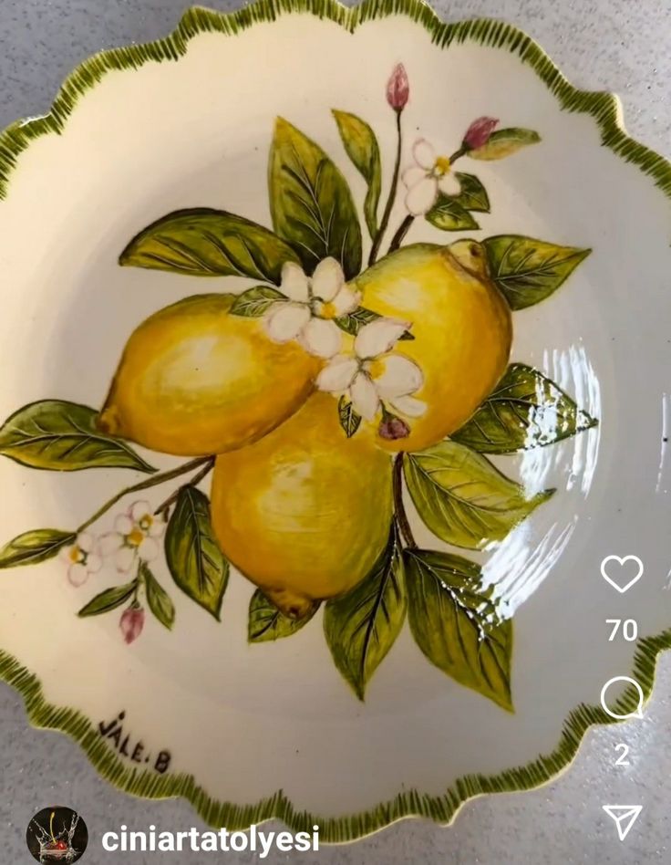 a plate with two lemons and flowers painted on it