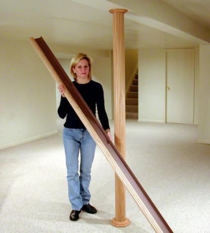 a woman is standing in an empty room with a large wooden object on the floor