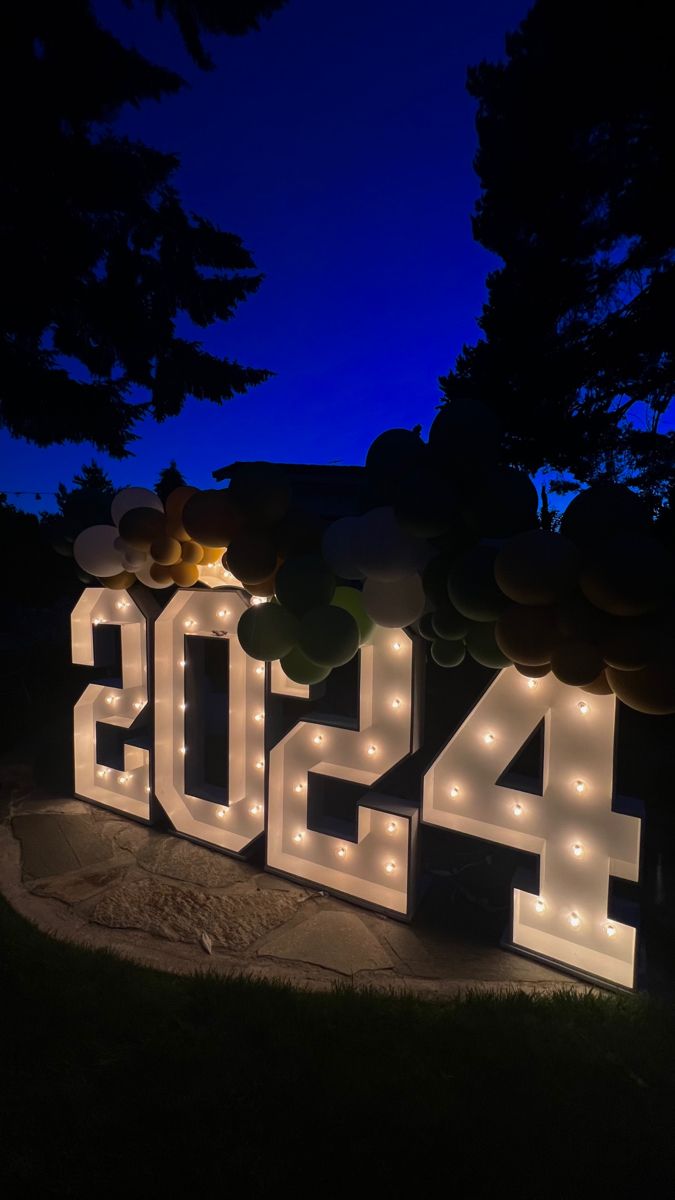 the letters are lit up in front of some trees