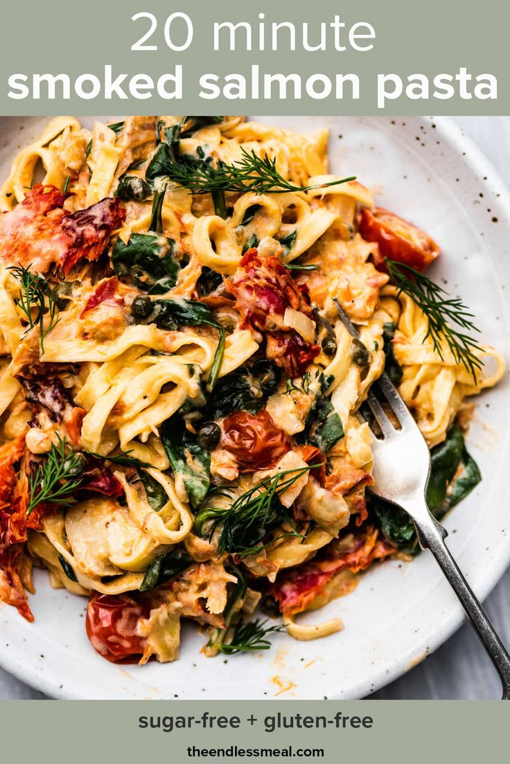 a white plate topped with pasta covered in sauce and garnished with fresh herbs