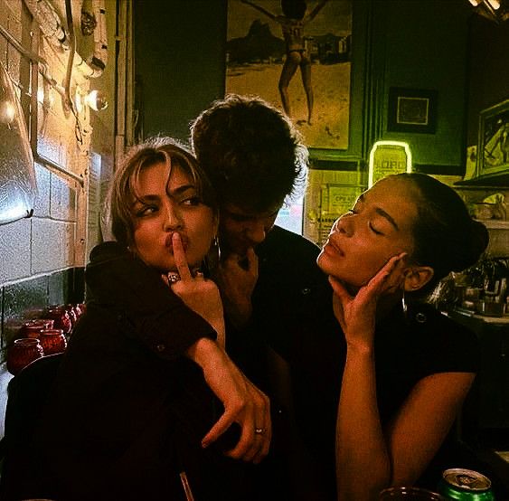 three women sitting at a table with their mouths open while one woman covers her mouth