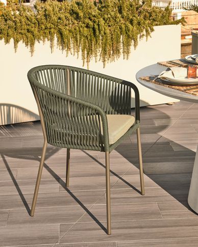 two chairs sitting on top of a wooden floor next to a table and potted plant