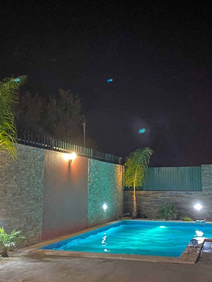 an empty swimming pool at night with lights on