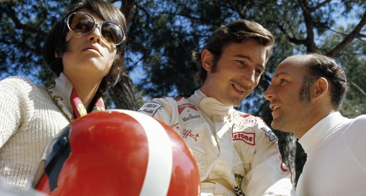 two men and a woman sitting next to each other in front of a red ball