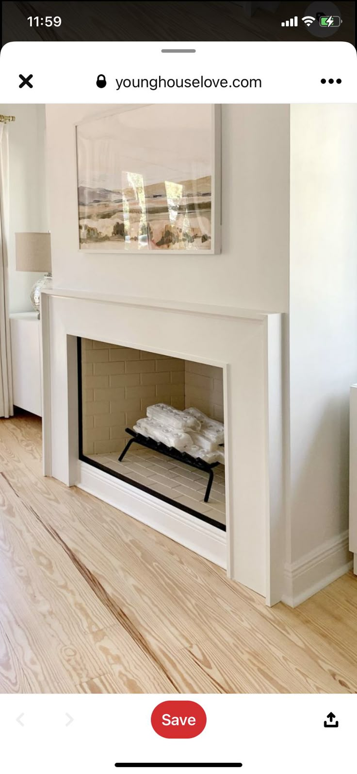 a white fireplace in a living room with wood flooring and a painting on the wall