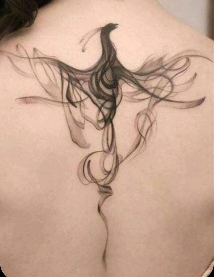 the back of a woman's neck with a bird tattoo on it