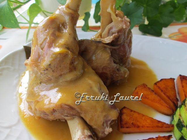 two pieces of meat on a plate with carrots and gravy