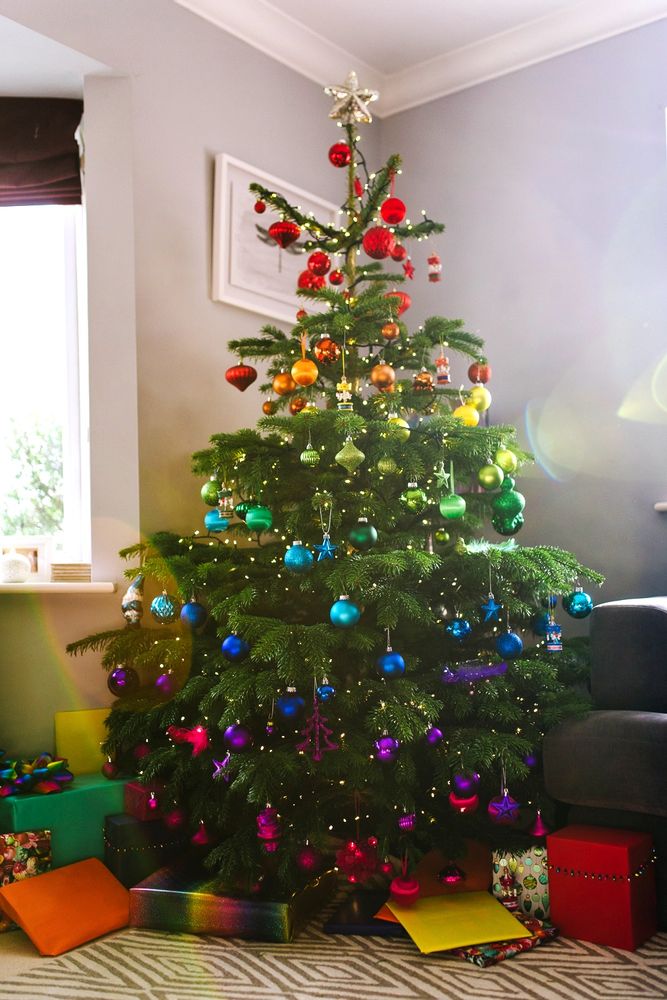 a brightly colored christmas tree with presents under it