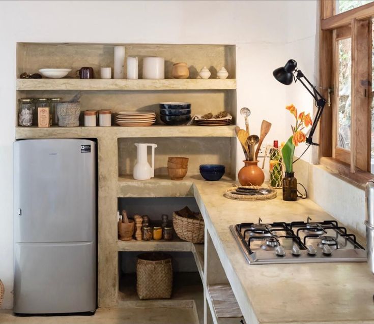 a kitchen with a refrigerator, stove and shelves