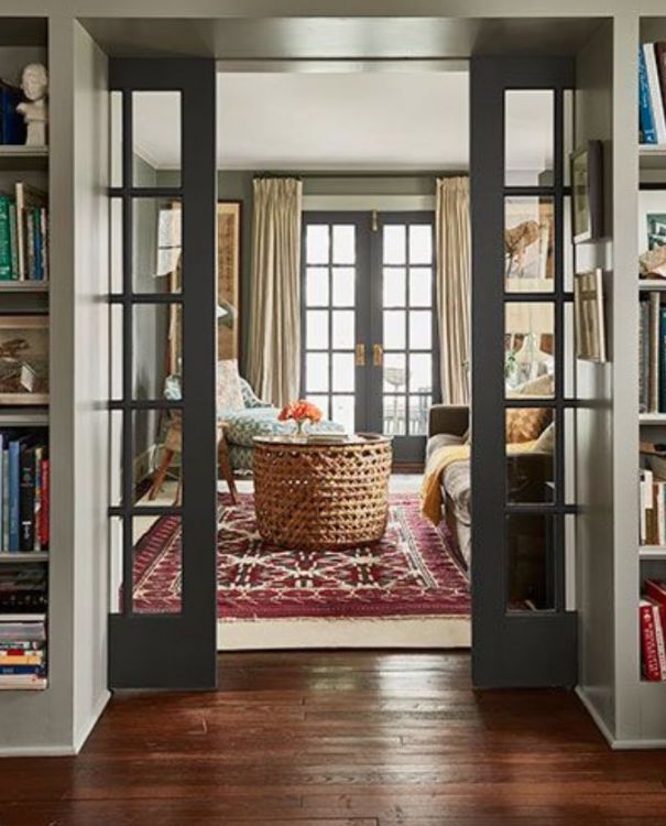 an instagramted photo of a living room with french doors and bookshelves