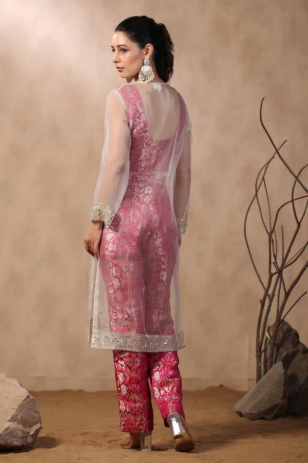 Ivory semi-sheer kurta with floral hand Embroidery. Comes with floral pattern pink brocade pant and crop top.
Components: 3
Pattern: Hand Embroidered
Type Of Work: Gota Patti, Pearls
Neckline: Round
Sleeve Type: Full
Fabric: Kurta: Organza, Pant and Crop Top: Pink
Color: Pink,White
Other Details: 
Attached lining
Approximate product weight: 0.5-1 kg
Occasion: Mehendi and Haldi - Aza Fashions Sheer Kurta, Pink Brocade, Floral Hand Embroidery, Pink Kurta, Crop Top Pink, Pant Set, Set For Women, Aza Fashion, Fashion Set