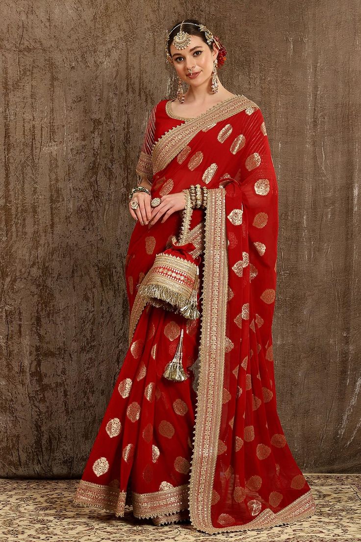 Red saree with all-over woven paisley motifs and dori, badla, kasab embroidery on the border. Comes with half sleeves blouse.
Component: 2
Pattern: Embroidery and Woven
Type Of Work: Dori, Badla and Kasab Work
Neckline: Scoop
Sleeve Type: Half
Fabric: Georgette Butta and Silk Chanderi; Lining: Taffeta Silk
Color: Red
Other Details: 
Embroidered border
Sleeves with bead drops
Low back with tie up and tassels
Note: Polti bag carried by the model is not for sale
Occasion: Wedding - Aza Fashions Polti Bag, Engagement Dress For Bride, Paisley Motifs, Indian Bridal Photos, Blouse Casual Fashion, Saree Designs Party Wear, Embroidered Saree, Saree Trends, Ethnic Outfits