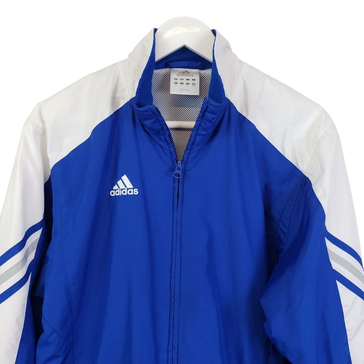 Classic Adidas track jacket that is a full zip design with a mesh lining. Front zip closure pockets and elastic at the wrists. Perfect for any active day or for a soccer game.Lined: YesNOTE that preloved pieces may have changed in size with wash and wear so please check approximate measurements for current size and fit.Size: Mens XSApproximate Measurements Lying Flat: Bust 19.5 in Waist 19.5 in Length 26 inCondition: Pre-Owned Like NewAll pieces are stored in a smoke-free, pet-free environment. Team-colored Long Sleeve Track Jacket For Sports, Sporty Team-colored Track Jacket For Sports Season, White Team Spirit Outerwear For Sports, Blue Adidas Sporty Windbreaker, Adidas Blue Sporty Windbreaker, Sporty Blue Adidas Windbreaker, White Team Spirit Sports Outerwear, Sporty Track Jacket For Sports Season, Sporty Track Jacket In Team Colors For Sports