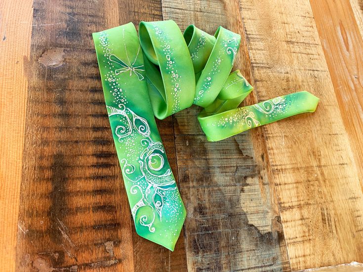 Hand-painted skinny tie in lime-green colorway. Floral art. The men's necktie is very bright and exclusive, can make a favorite accessory for a young gentleman who likes to cheer up his everyday look with silk ties. It is also a great groomsmen gift for a wedding. The men's necktie has a nice touch. Such accessories for men perfectly complements the business suit. The accessory will look great both in the office and at the evening or party event. The model has a stylish coloring. The material is Green Tie For Spring Gift, Green Ties For Spring Gift, Green Ties As Spring Gifts, Adjustable Green Tie For Party, Green Adjustable Tie For Party, Green Summer Ties As Gift, Adjustable Green Ties For Party, Green Summer Ties As Gifts, Green Summer Ties For Gift