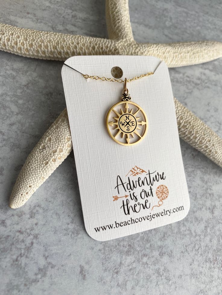 A perfect necklace for any adventure lover! Compass is bronze and detailed on one side only. Measures approximately 7/8 and hangs 1 1/8 inch including the loops. Has a protective anti tarnish coating, will eventually patina darker.Chain is a 14k gold filled cable chain with spring ring clasp.  includes message card wit Gold Compass Necklace, Beach Cove, Adventure Is Out There, Compass Necklace, Graduation Gifts For Her, Macro Lens, Message Card, Spring Rings, Cable Chain