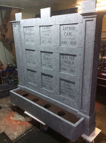 a cement monument with names and numbers on it in a garage next to other cars