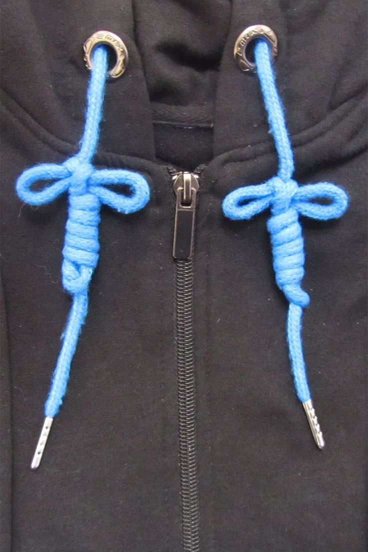 a close up of a person wearing a black jacket with blue ropes attached to it