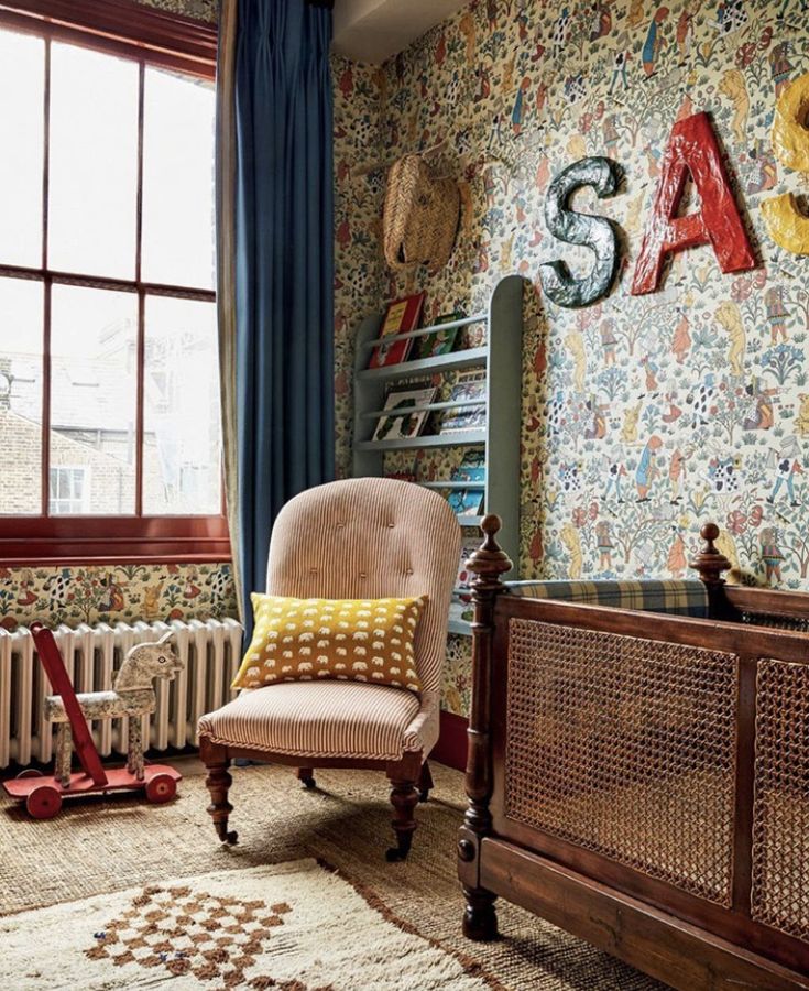 a bedroom with colorful wallpaper and a chair in front of a window that reads sasa