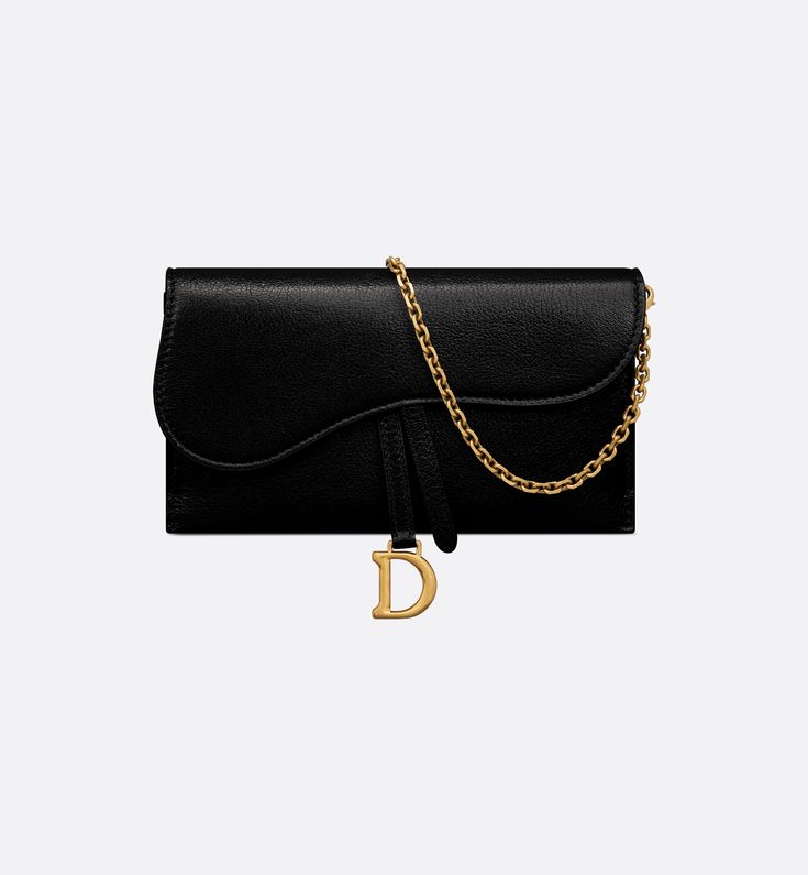 The Saddle pouch with chain, crafted in black goatskin, is a hybrid creation with a both modern and streamlined design. The accessory has an asymmetrical flap featuring an antique gold-finish metal D stirrup. Thanks to its detachable chain strap, the small pouch may be worn over the shoulder, crossbody or carried by hand.. Dior Saddle Wallet On Chain, Dior Wallet On Chain, Saddle Pouch, Wallet With Chain, Aesthetic Clothing Stores, Christian Dior Couture, Dior Couture, Black Wallet, Dior Wallet