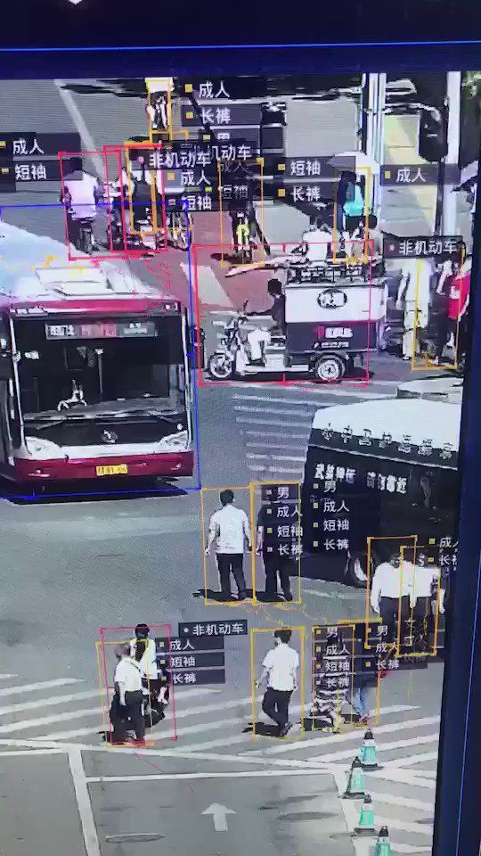 people crossing the street at an intersection with buses and cars on it, in china