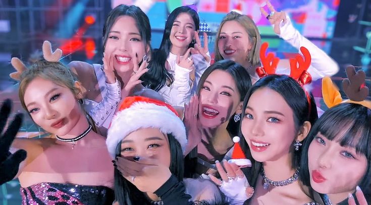 a group of young women standing next to each other in front of a christmas tree