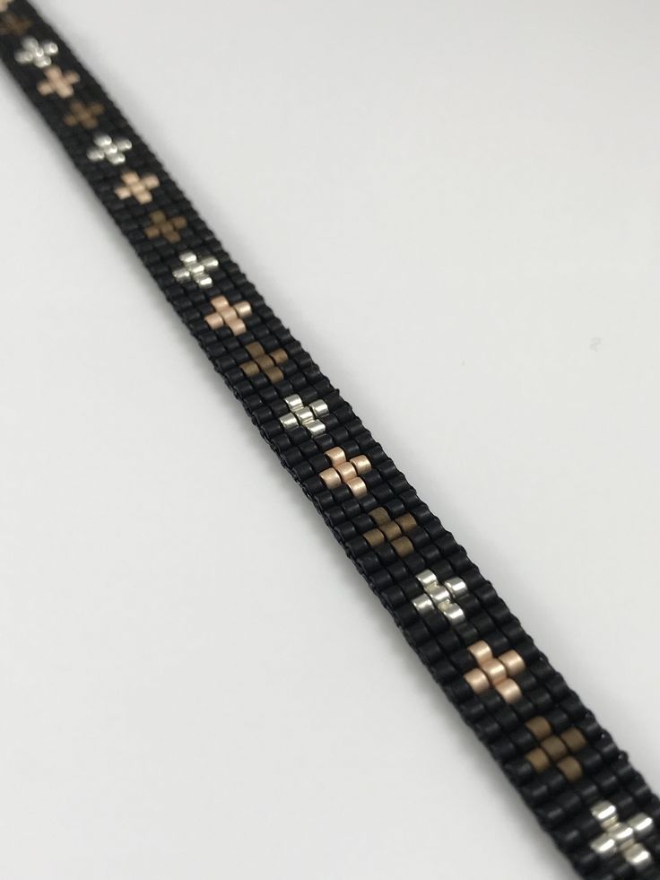 a black and gold bracelet with crosses on it