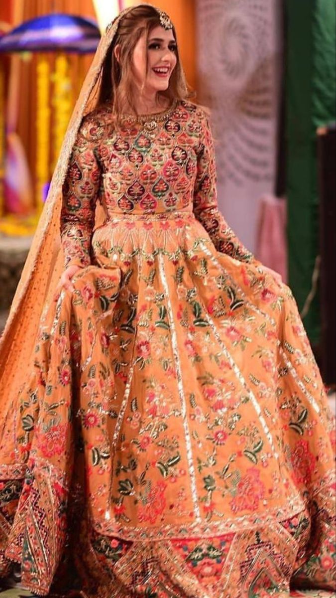 a woman in an orange and gold wedding gown