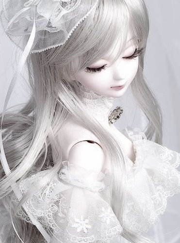 a white doll with long hair wearing a veil