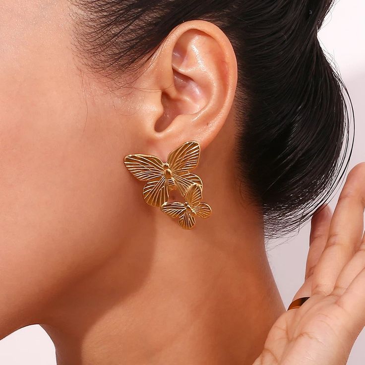 These Large Gold Butterfly Earrings make a bold statement with their stunning design. Perfect for adding a touch of elegance and sophistication to any outfit. These earrings will surely catch attention and elevate any look. DETAILS & SIZE Sold as a pair Finish: 18K gold plate Material: Stainless Steel Measurements: 1.6"x1.2" Weight: 12.6 grams Comes with friction earring backs Waterproof, tarnish-resistant, and nickel free Shop Earrings to curate your ear stack! Pierced Bridal Earrings For Evening, Bridal Pierced Earrings For Evening, Elegant Metal Jewelry With Butterfly Shape, Elegant Gold Butterfly Earrings, Elegant Metal Butterfly Jewelry, Elegant Gold Butterfly-shaped Earrings, Elegant Metal Butterfly Shaped Jewelry, Elegant Single Butterfly Earring, Elegant Butterfly Shape Metal Jewelry