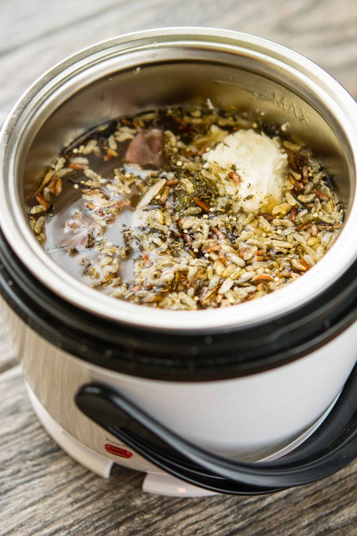 a crock pot filled with food sitting on top of a wooden table