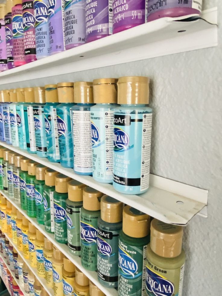 many different types of paint on shelves in a store