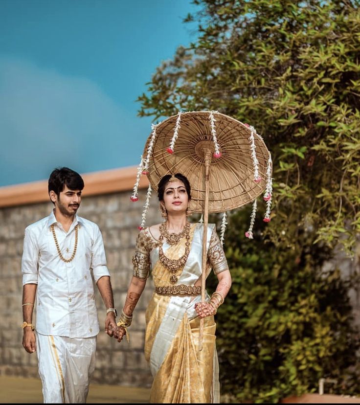 a man and woman holding hands under an umbrella