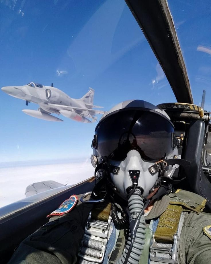 a fighter jet flying through the sky next to another plane