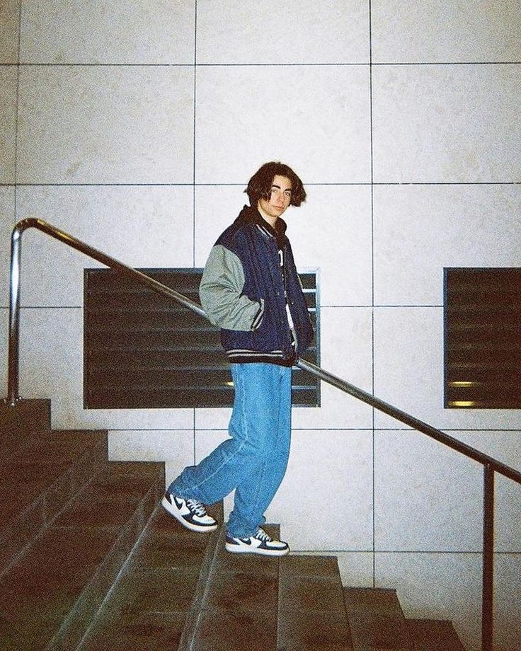 a young man is walking down the stairs