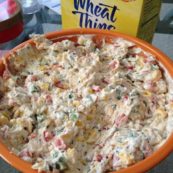 an orange bowl filled with food on top of a table