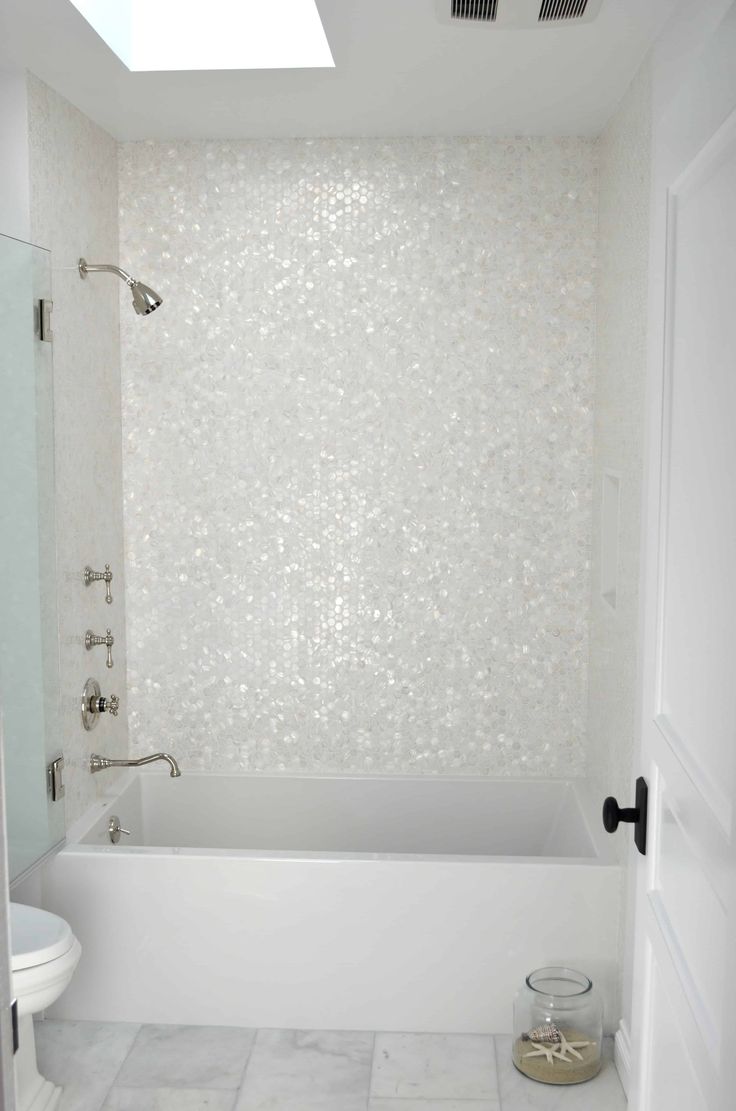 a white bathroom with a skylight above the bathtub