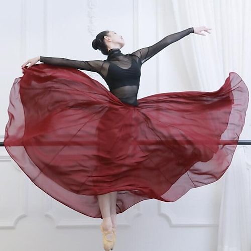 a ballerina in a black leotard and red skirt is posing for the camera