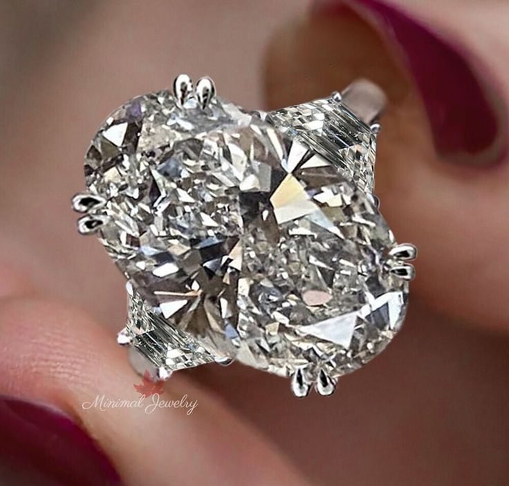 a close up of a person holding a ring with a diamond in it's center