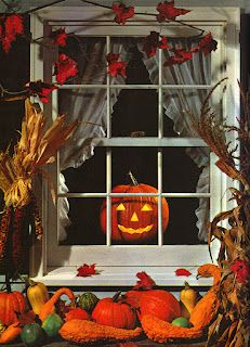 pumpkins and corn on the window sill in front of a decorated halloween scene