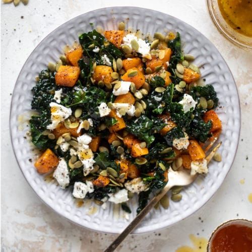 a white bowl filled with vegetables and cheese